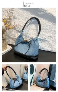Detail of blue denim underarm bag with black leather bow and stylish patchwork design