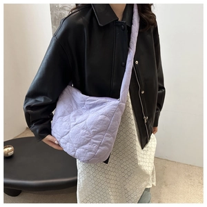 Detail of lavender quilted puffer tote bag featuring heart pattern embroidery on shoulder