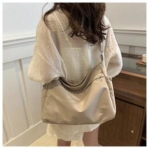 Rear view of model wearing a large cream canvas shoulder bag in a cozy home setting