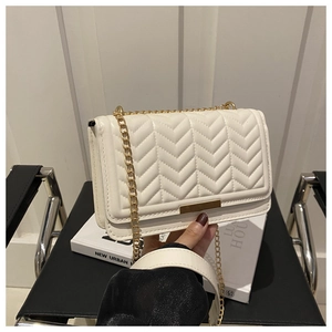 Detail of white quilted leather crossbody bag with gold chain and V-shaped stitching