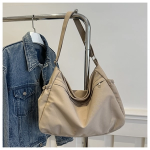 Detail of beige canvas hobo bag with side drawstring and external zipper pocket