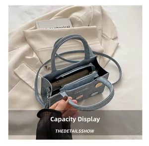 Internal view of blue denim texture handbag showing zipper pocket and large capacity