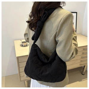 Détail de la texture matelassée en cœur du sac noir et de la bandoulière nouée originale