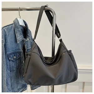 Detail view of the dark grey canvas bucket bag with adjustable strap and side zipper pocket