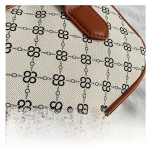 Detailed close-up of canvas texture with geometric pattern and brown leather piping