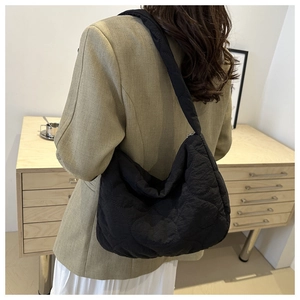 Vue détaillée du sac cabas matelassé noir en forme de croissant avec bandoulière large