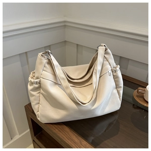 Large beige nylon bucket bag with drawstring detail and shoulder straps for women