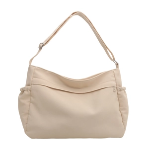 Large beige nylon bucket bag with adjustable shoulder strap and side drawstring pockets