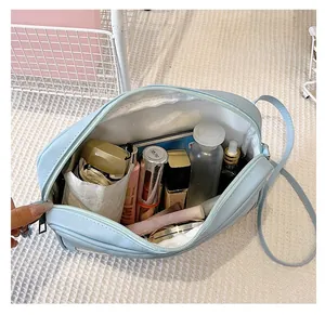Vista ravvicinata della grande capacità interna della borsa cosmetica in PU azzurro