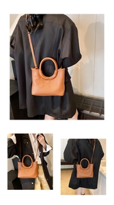 Detail of caramel brown litchi grain leather handbag with integrated round handle design