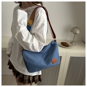 Details zur blauen Canvas Umhängetasche mit buntem Schultergurt und Leder-Logo-Etikett