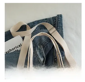 Close-up of durable canvas tote strap with metal adjustment buckle and red cherry print