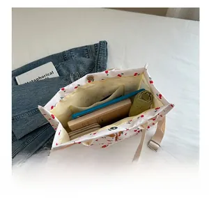 Interior storage of cherry print canvas tote bag showing tablet and daily essentials