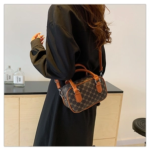 Detail of retro mini boston bag with monogram pattern and brown leather straps