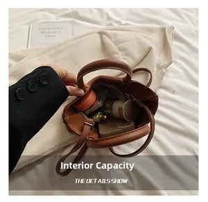 Internal capacity of brown leather tote bag showing mobile phone and cosmetics inside