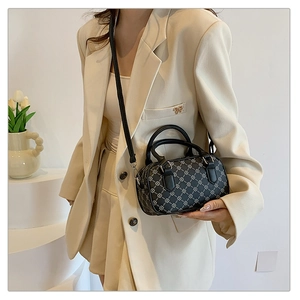 Chic retro patterned small cylinder bag worn by a model in a minimalist modern setting