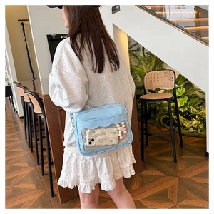 Dettaglio di una borsa ita azzurra con finestra in PVC e ciondolo a cuore di perle