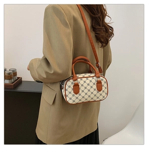Detail shot of the patterned canvas surface and leather trim on this vintage crossbody bag