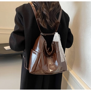 Détail du sac cabas brillant marron foncé avec ruban en dentelle et gaufrage numéro 10