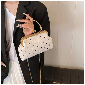 Close-up of retro polka dot tweed shell bag with gold metal frame and chain strap