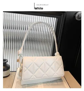 Close-up of white quilted leather flap bag with elegant knotted shoulder strap detail