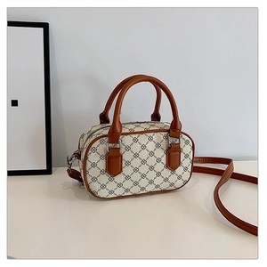 Detail of floral canvas bowling bag with brown leather handles and silver hardware
