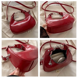 Detail view of red crescent shoulder bag showing interior capacity and glossy leather texture