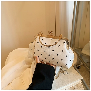 Detail of vintage polka dot shell bag with golden metal frame and chain strap