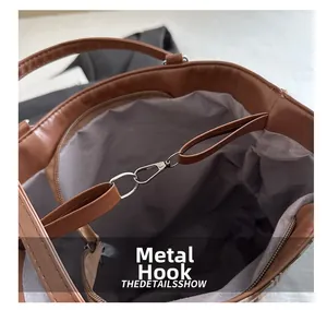 Détail de l'intérieur du sac en cuir marron avec crochet métallique et poche zippée