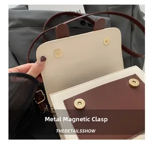 Detail view of the magnetic snap closure and two-tone PU leather on this stylish crossbody bag