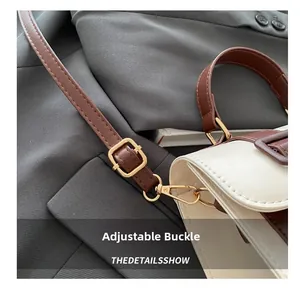 Close-up of golden metal buckle and adjustable brown strap on a stylish handbag