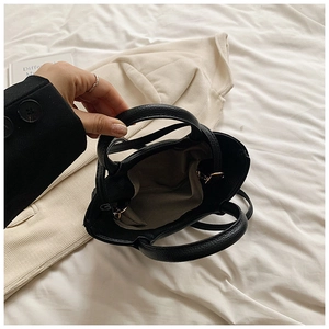 Detail of black pebbled leather bag with golden hardware and adjustable slim shoulder strap