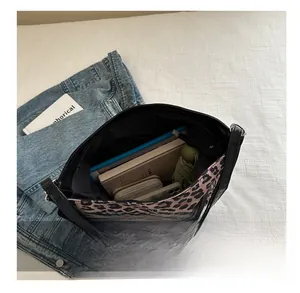 Detail view of the spacious leopard print tote bag interior holding daily essentials