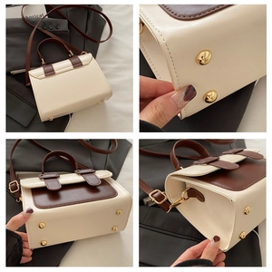 Detail view of contrast color crossbody bag with protective metal feet on bottom