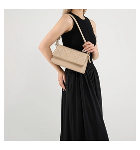 Detail of beige quilted shoulder bag showing triangular texture on faux leather finish