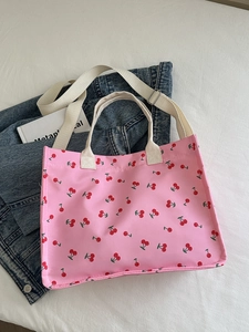Pink cherry print canvas tote bag with white adjustable straps and handles