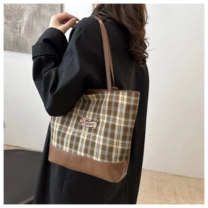 Détail du sac cabas à carreaux avec broderie teckel et bandoulière en cuir brun
