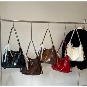 Détail du sac cabas chic avec le chiffre dix en relief et un nœud en dentelle décoratif