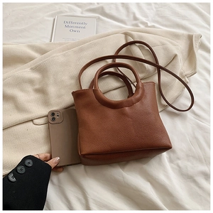 Brown lychee texture handbag shown with phone for size reference and scale visualization