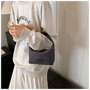 Détail du petit sac polochon gris à pois rouges avec étiquette en cuir Rich Rabbit