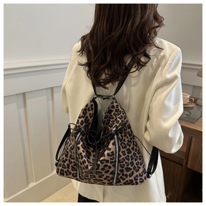 Detail view of stylish leopard print backpack with drawstring on a female model