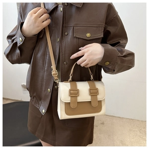 Detail of a two-tone PU leather crossbody bag featuring vintage buckles and top handle