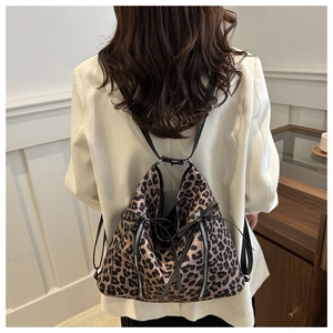 Detail of leopard print multi-functional backpack with decorative bow and vertical zippers