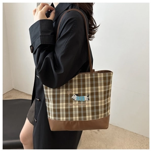 Vue détaillée du sac cabas à carreaux marron avec broderie chien et base en cuir