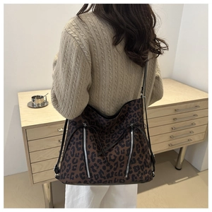 Detailed view of a large leopard print tote bag with silver zippers and bow accents