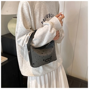 Sac à main croissant gris avec motif d'étoiles et large poignée noire style lifestyle