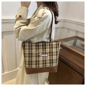 Détail d'un sac cabas à carreaux marron avec broderie et longues bretelles en cuir