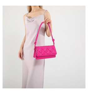 Detail of rose pink quilted shoulder bag featuring star pattern and knot strap detail