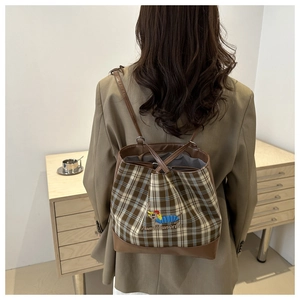 Détail du sac seau à carreaux rétro avec finitions cuir et broderie chien au dos