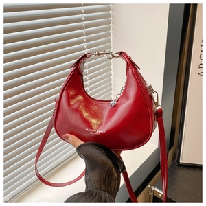 Detail of red crescent leather handbag with silver chain and white fashion typography